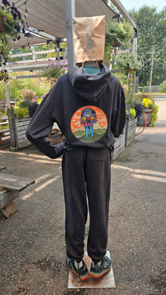 Person wearing a black hoodie with a colorful graphic design outdoors.